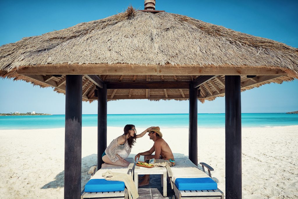 Couple under beachfront cabana during destination mini-moon