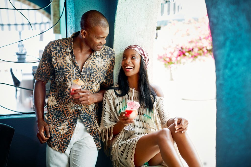 Couple share a happy moment over all-inclusive cocktails