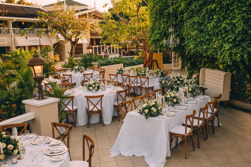 Sunset tablescape with white linens and green and ivory florals.